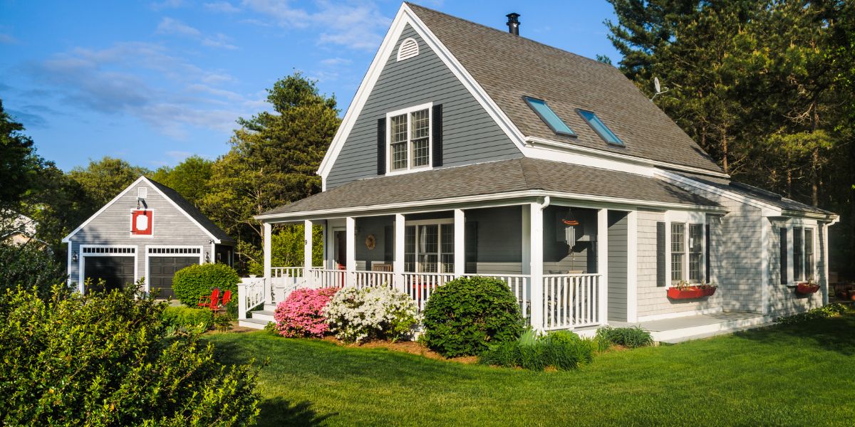 Gray Cape Cod house with white trim and front porch.