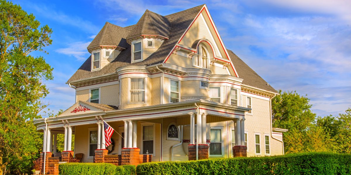 Victorian-style house with intricate detailing and American flag.