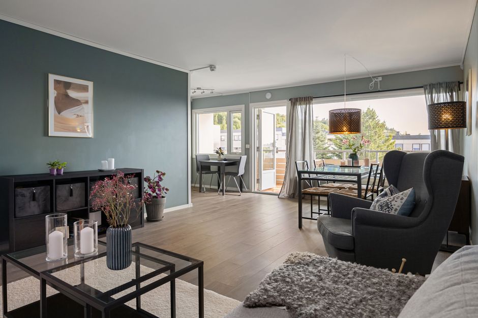 The final result of a professional photoshoot: a bright, perfectly composed image of a luxury condo living room with a stunning view of the Calgary skyline.