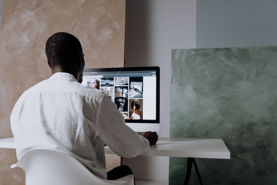A person at a clean, modern workstation browses a website with a gallery of professional real estate photos, symbolizing how buyers find listings through image search.